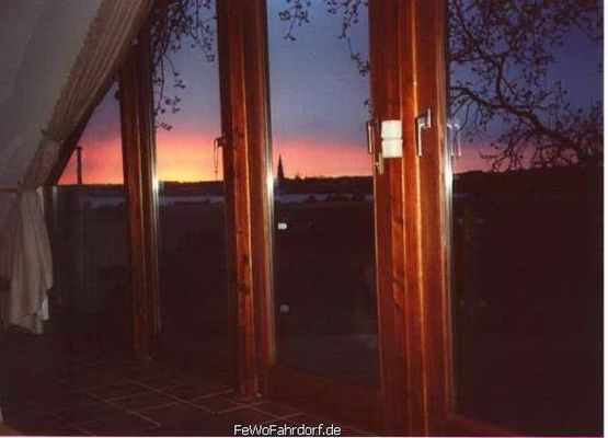 Fensterfront mit Blick auf den Sonnenuntergang über der Schlei und den Dom