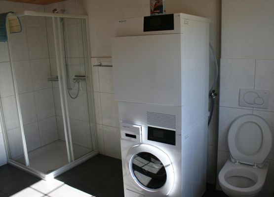 Badezimmer mit Waschmaschine und Tumbler